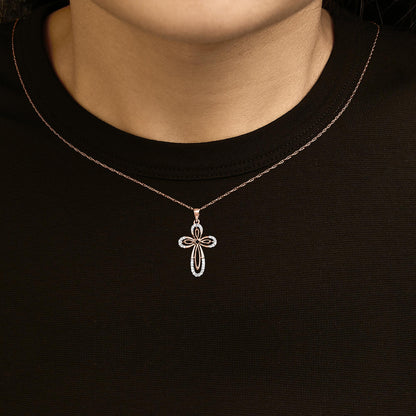 Rose-colored necklace with a cross-shaped pendant adorned with round white gemstones in prong settings, shown worn on a model from the front angle.