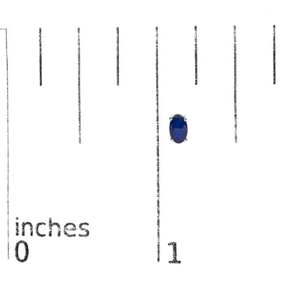 Close-up front view of white metal earrings featuring oval-shaped blue gemstones in four-prong settings shown on a measurement scale.