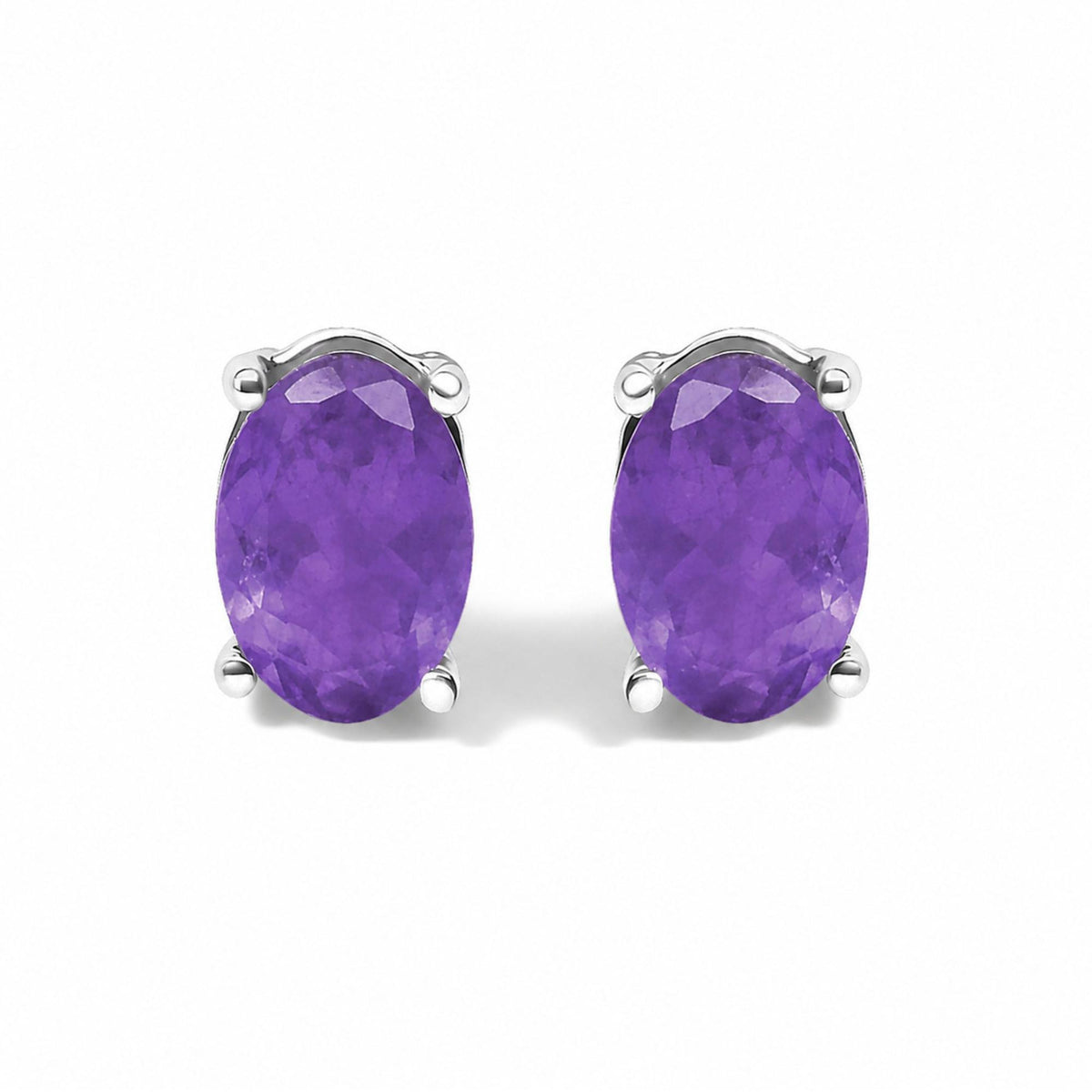 Close-up front view of a pair of white earrings with oval-shaped purple gemstones set in 4-prong settings.