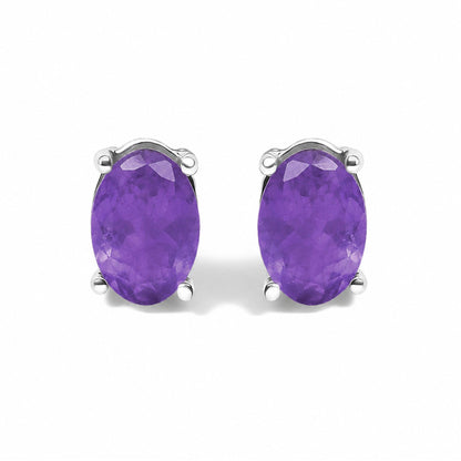 Close-up front view of a pair of white earrings with oval-shaped purple gemstones set in 4-prong settings.