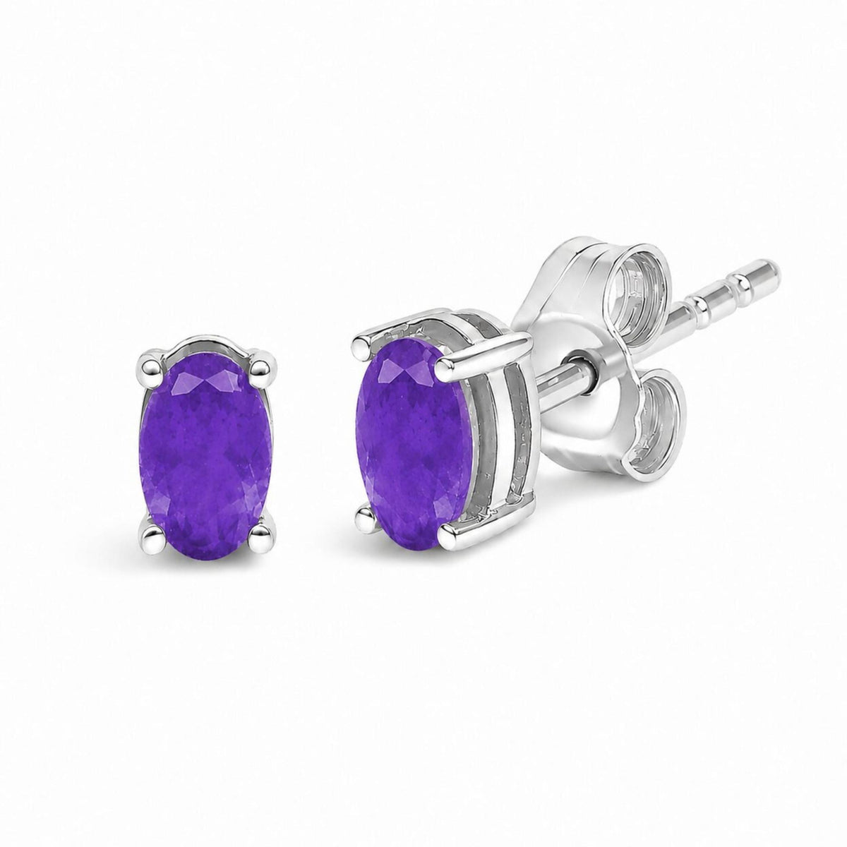 Close-up front and side view of white metal stud earrings with oval-shaped purple gemstones in four-prong settings.