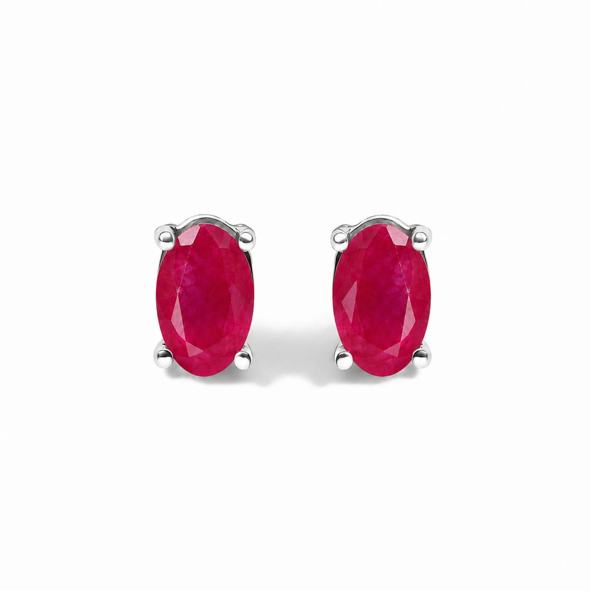 Front view of sterling silver 5x3mm natural oval gemstone solitaire stud earrings with red stones on white background