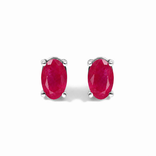 Pair of white metal stud earrings with oval red gemstones in four-prong settings, shown in a front-facing close-up view.