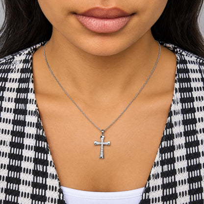Close-up front view of a model wearing a white necklace with a cross-shaped pendant featuring multiple round white gemstones in prong settings.