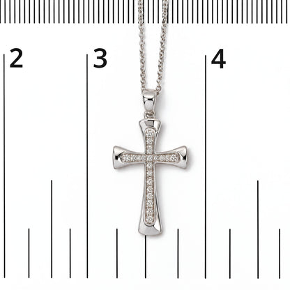 Close-up front view of a white metal cross-shaped necklace pendant with round white gemstones in prong settings on a chain, shown on a measurement scale.