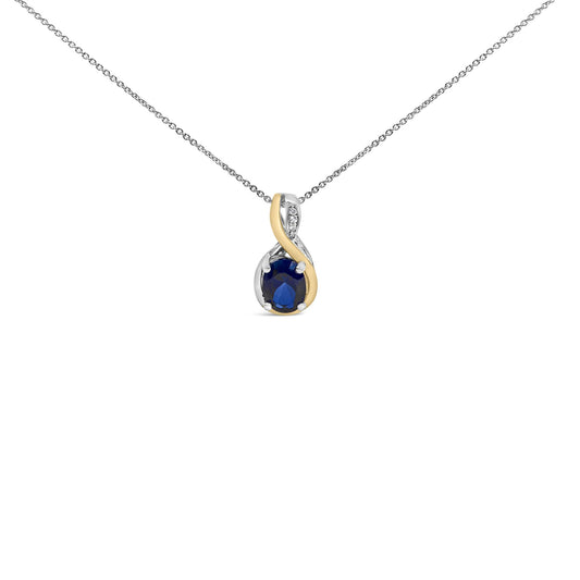 Close-up front view of a necklace pendant on a chain, featuring an oval blue gemstone held by a two-tone twisted metal setting with three small white gemstones above it.