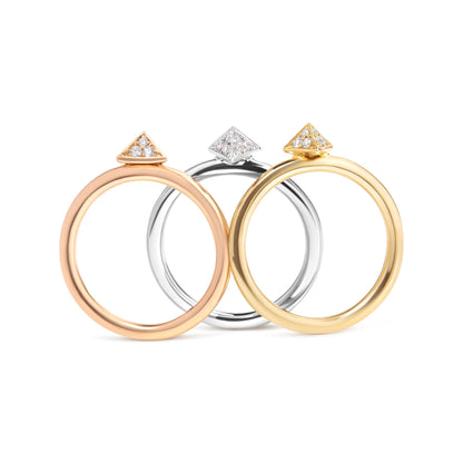 Front-facing shot of three rings in yellow, white, and rose metal colors, each featuring a triangular top with white round pave-set gemstones.