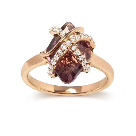 Close-up front angle of a rose metal ring featuring a central marquise-shaped purple gemstone held by tension setting and crossed by two bands set with small round white gemstones in a pave setting.