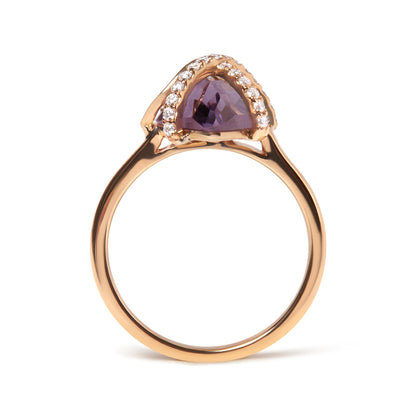 Front-facing view of a rose-colored ring featuring a purple gemstone in a marquise shape with tension setting, surrounded by a pave of small white round gemstones.