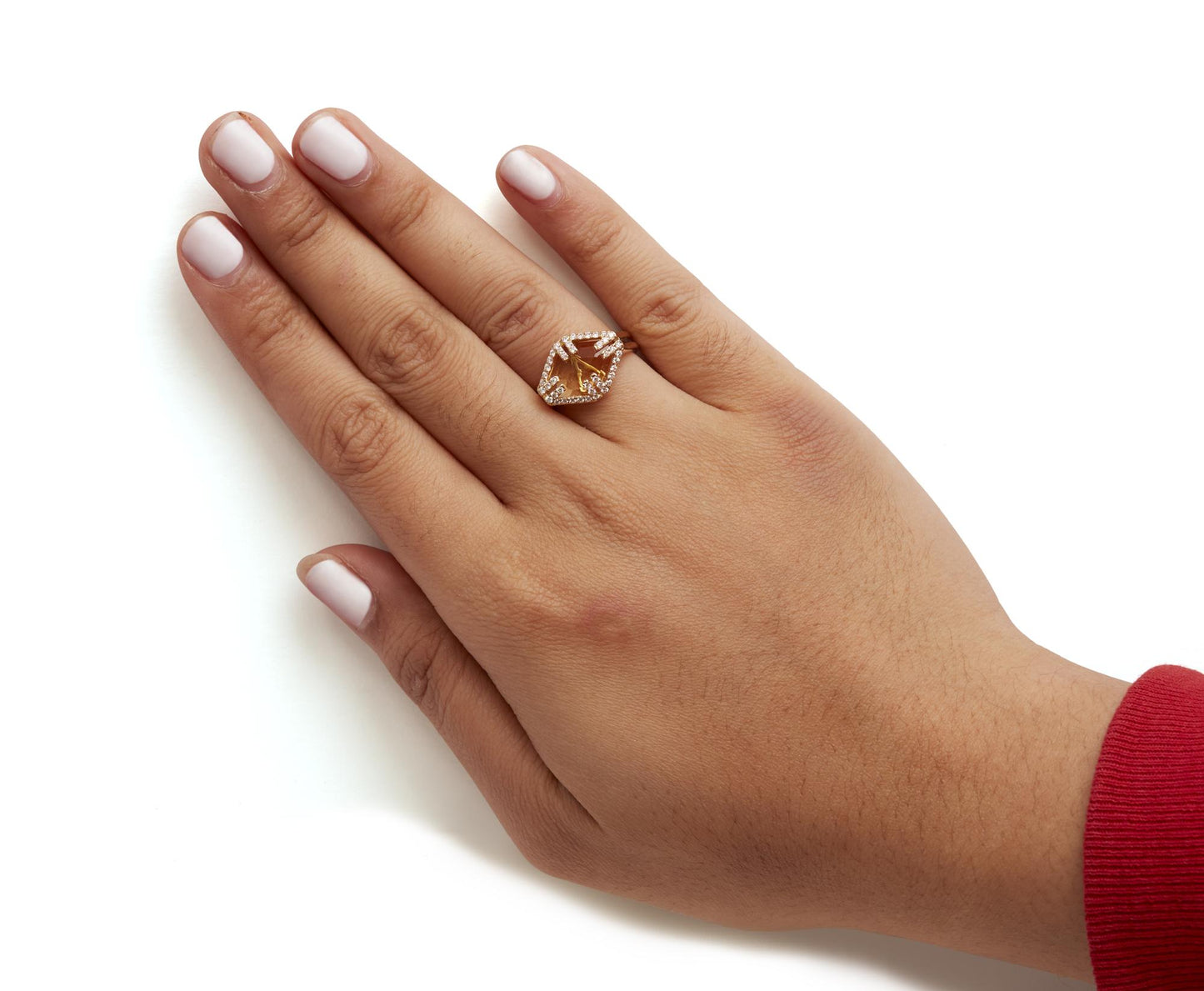Yellow metal ring with a marquise yellow gemstone surrounded by multiple round white gemstones in a pave setting, worn on a model's hand, shot from above at an angle.