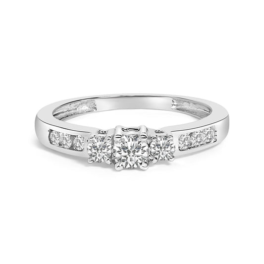 White metal ring with a center round white gemstone in a four-prong setting, flanked by two smaller round white gemstones also in four-prong settings, and additional round white gemstones in channel settings on the band, shown from a front angle on a white background.