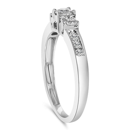 White metal ring shown from a side angle with two round white gemstones in 4-prong settings elevated above the band and a channel set row of round white gemstones on the band.