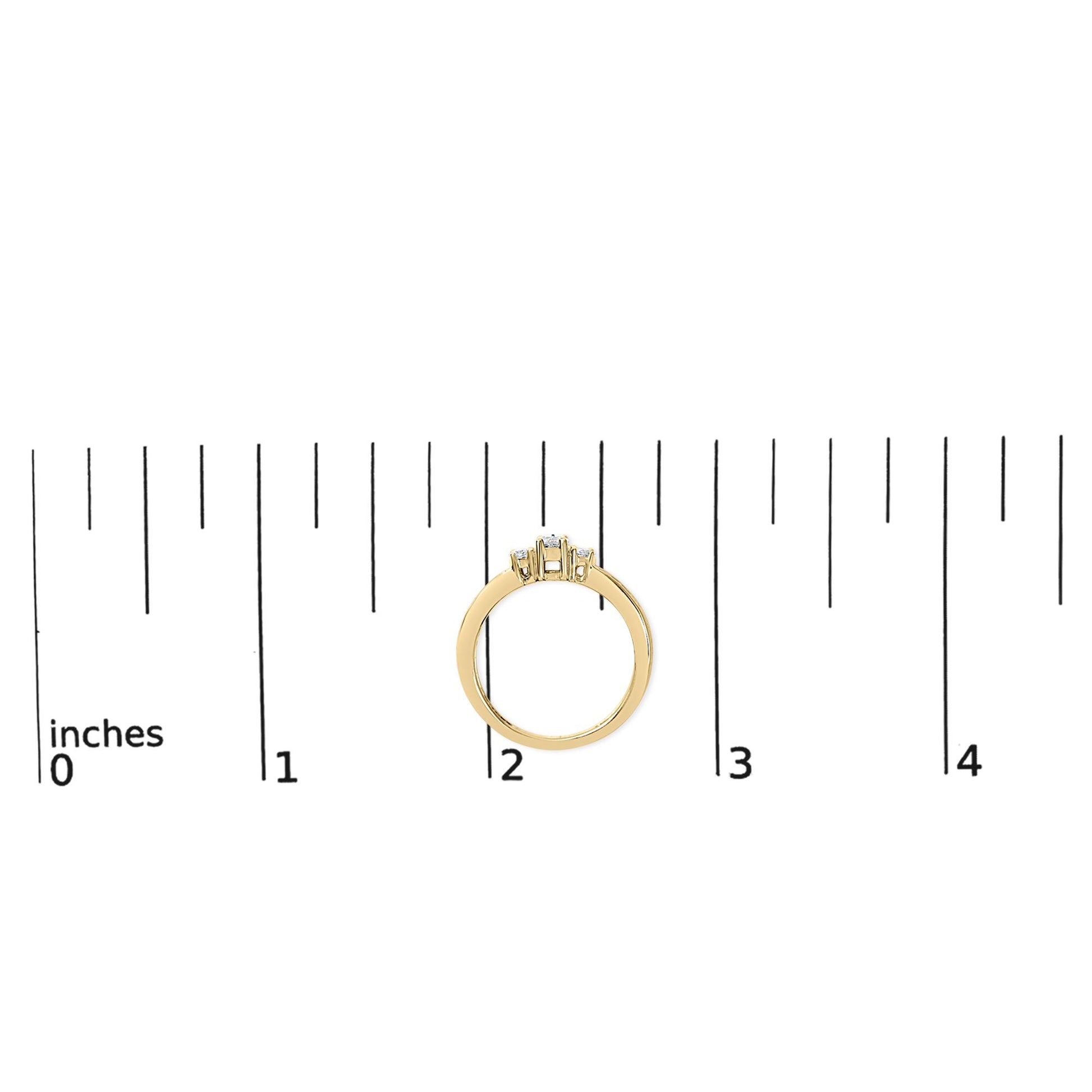 Yellow ring with one round white gemstone in a 4-prong setting flanked by two smaller round white gemstones in 4-prong settings and six small round white gemstones in a channel setting, shown from the side on a ruler scale.
