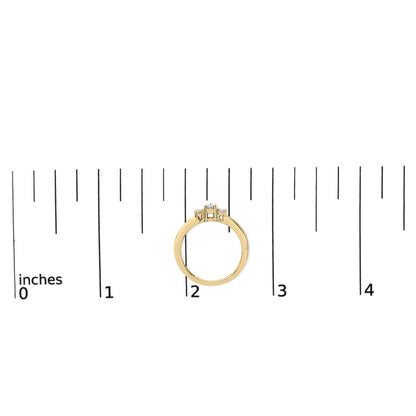 Yellow ring with one round white gemstone in a 4-prong setting flanked by two smaller round white gemstones in 4-prong settings and six small round white gemstones in a channel setting, shown from the side on a ruler scale.