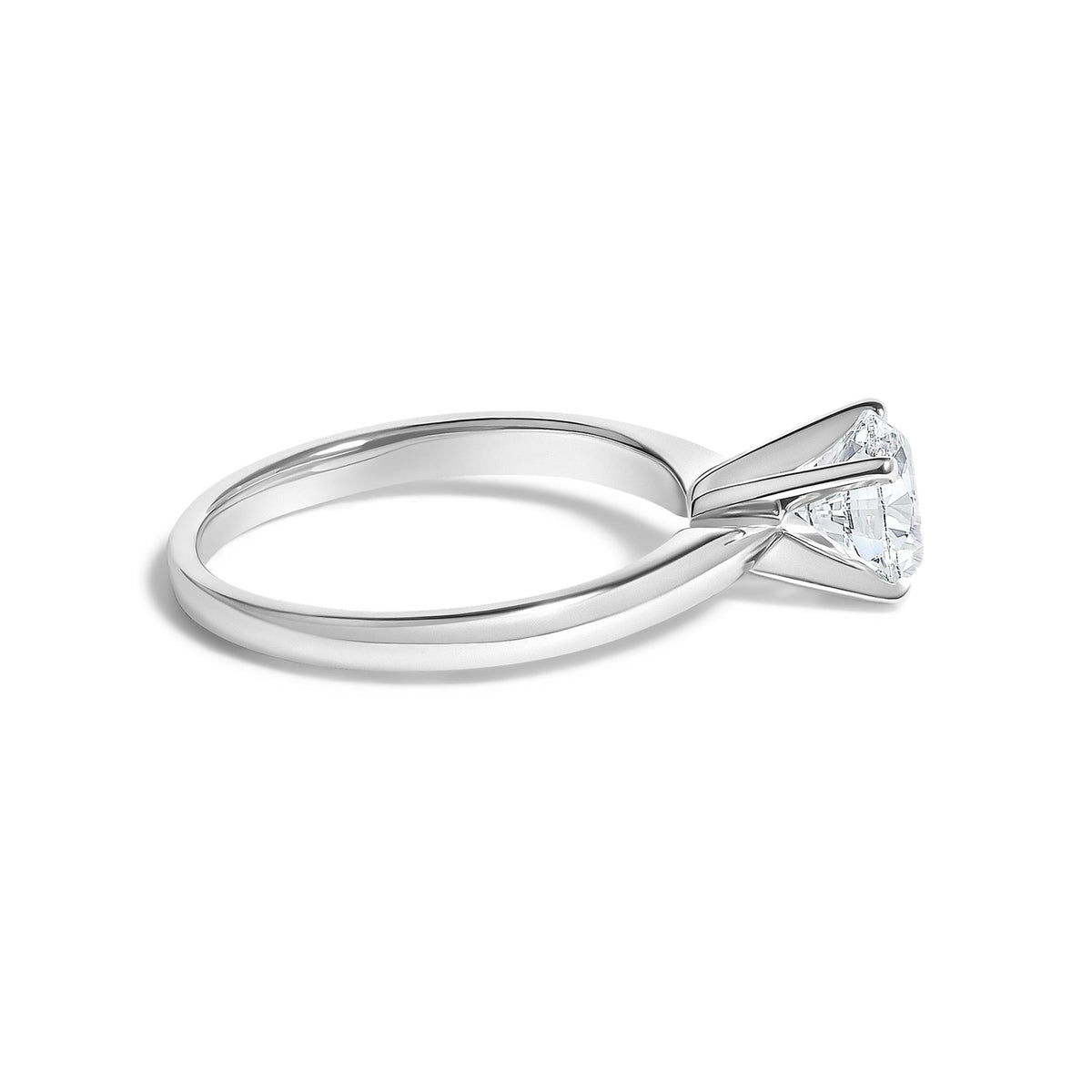 Close-up angled view of a white ring featuring a single round white gemstone in a 4-prong setting.
