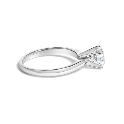 Close-up angled view of a white ring featuring a single round white gemstone in a 4-prong setting.