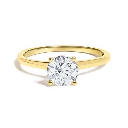 Close-up front angle of a yellow band ring with a round white gemstone in a four-prong setting.