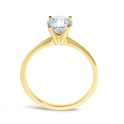 Close-up front view of a yellow metal ring with a single round white gemstone set in a four-prong setting.