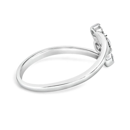 Side view of a white metal ring with a curved band holding one round white gemstone and two round white gemstones in shared prong settings.