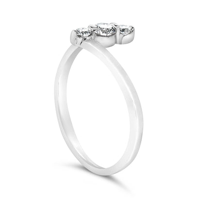 White metal ring with three round white gemstones in shared prong settings, shown at a side angle on a white background.