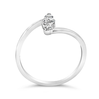 Close-up front angle of a white metal ring featuring a single round white gemstone and two round white gemstones in shared prong settings.