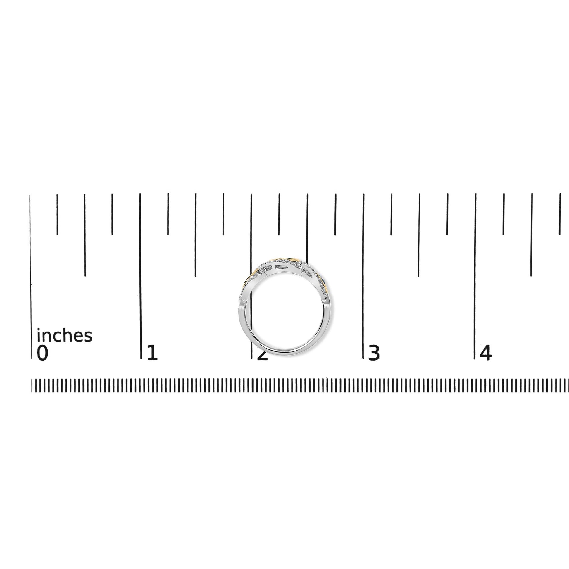 Ring with yellow and white metal featuring round white gemstones in prong settings and round blue gemstones in bezel settings, shown from the top on a ruler scale.