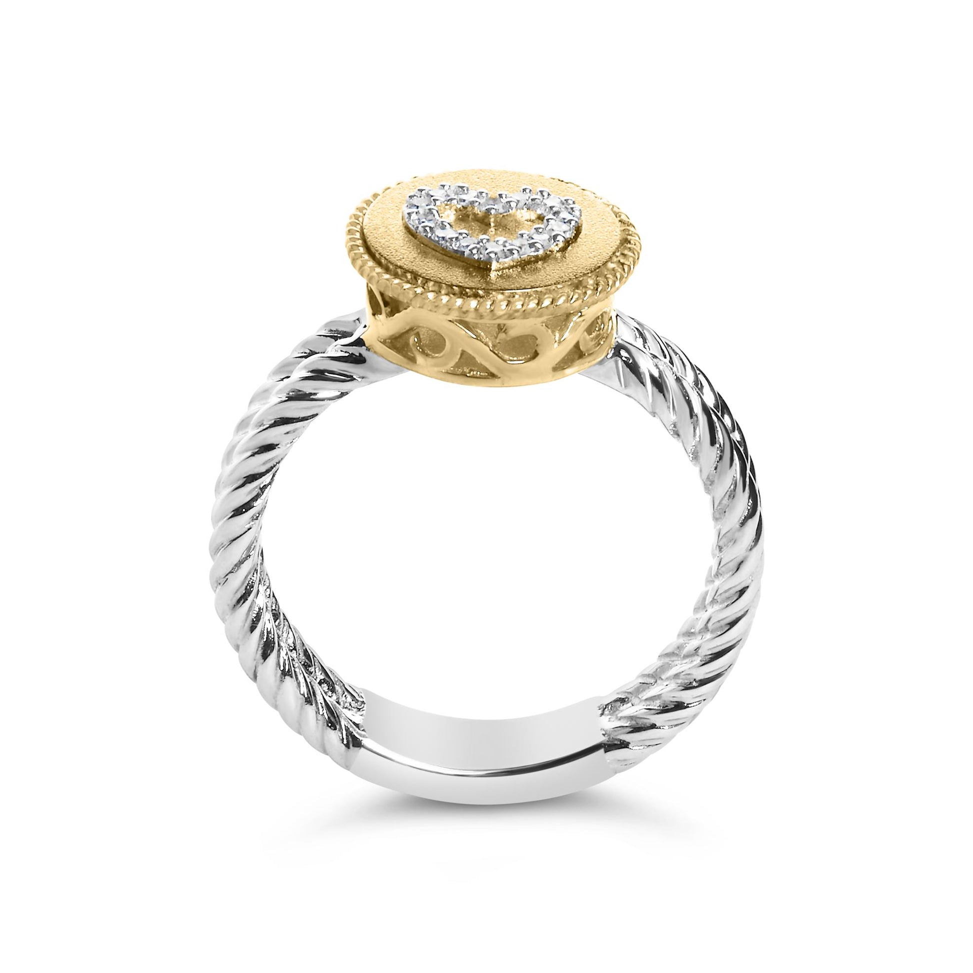 Close-up front angle of a ring with a twisted white metal band and a yellow metal round top featuring a heart shape of white round gemstones in shared prong settings.