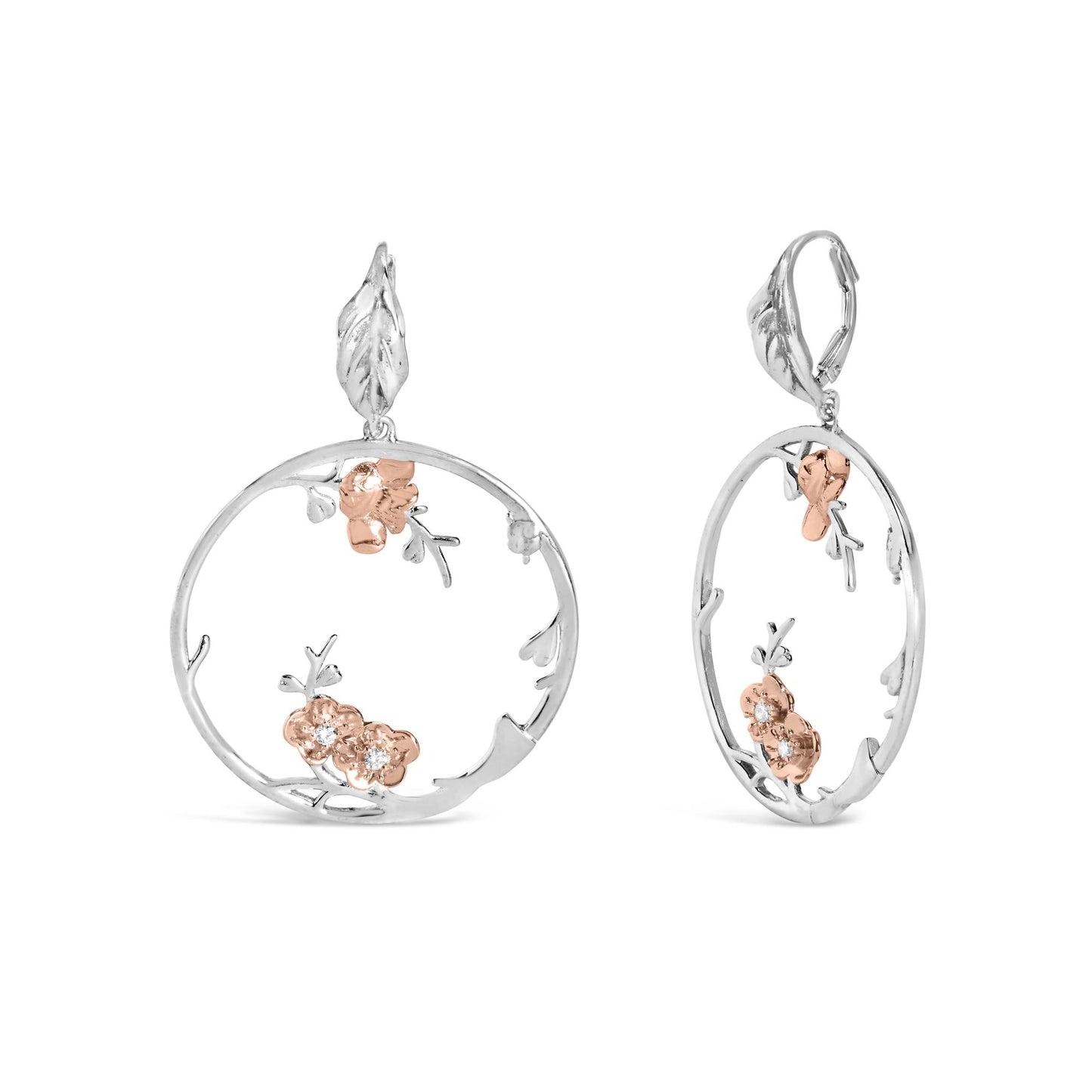 Front and side view of white and rose colored metal earrings with open circular design, floral accents, and small white gemstones, isolated on white background.