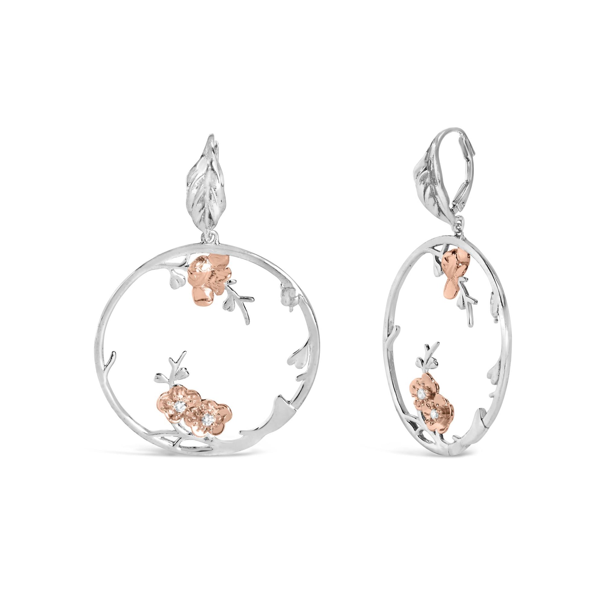 Front and side view of white and rose colored metal earrings with open circular design, floral accents, and small white gemstones, isolated on white background.