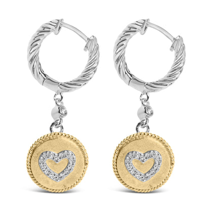 Pair of hoop earrings with twisted white metal design, each featuring a dangling round yellow metal charm with a heart shape outlined by white gemstones, shown from the front.