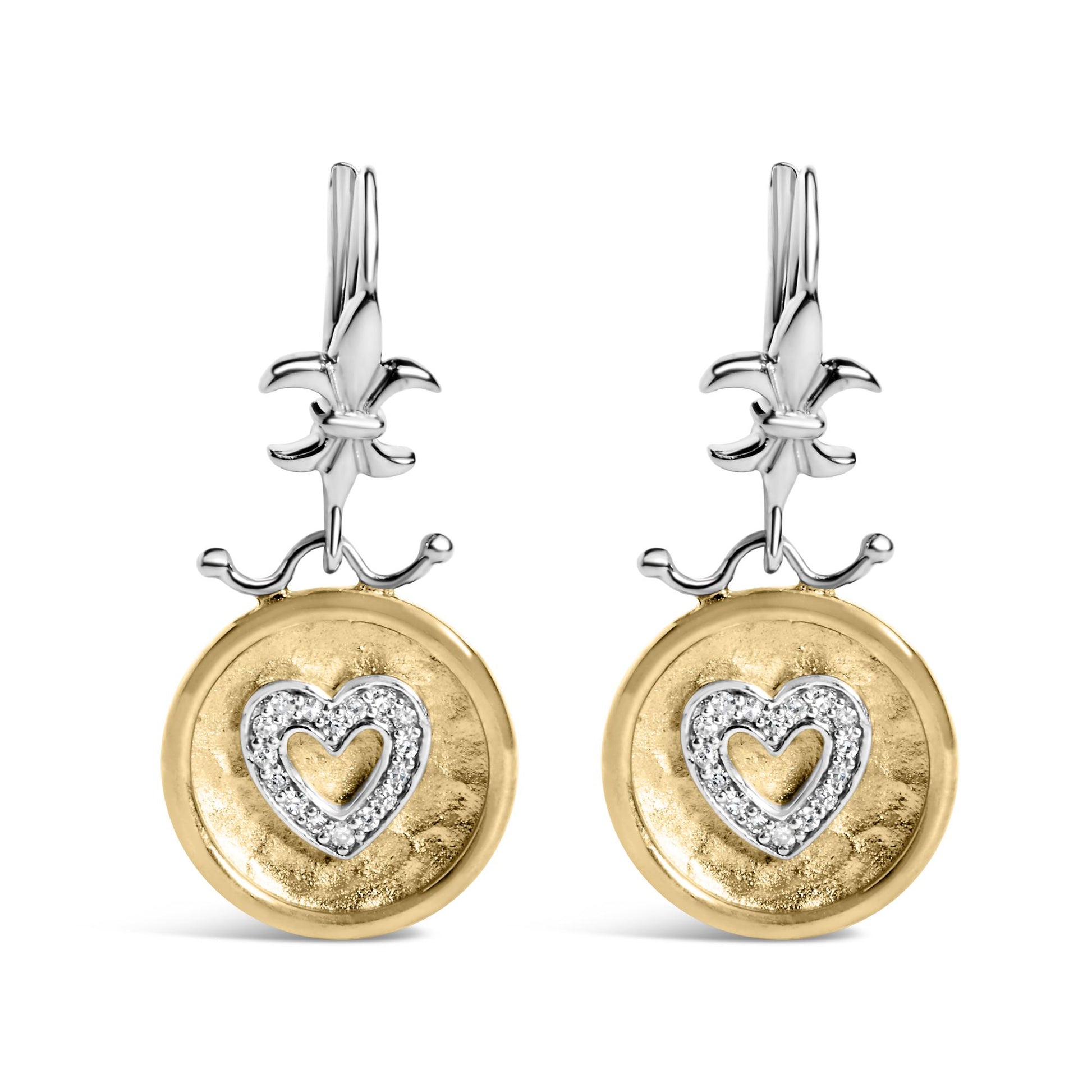 Front-facing shot of a pair of two-tone earrings with white metal Fleur-de-lis tops and round yellow metal discs hanging below, each disc featuring a heart shape outlined with white gemstones in shared prong settings.