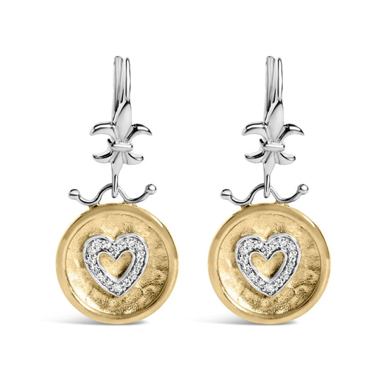Front-facing shot of a pair of two-tone earrings with white metal Fleur-de-lis tops and round yellow metal discs hanging below, each disc featuring a heart shape outlined with white gemstones in shared prong settings.