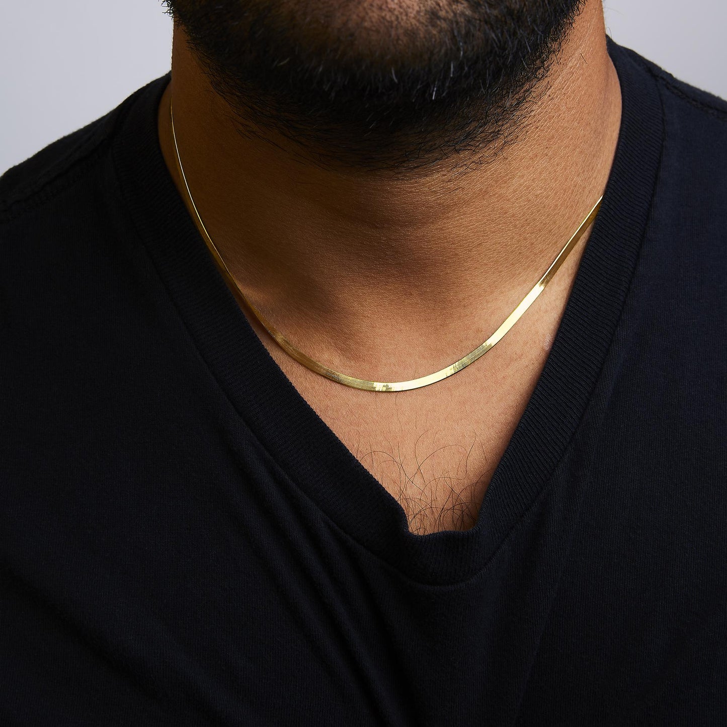Yellow chain necklace with a smooth flat design, shown worn on a model, front close-up angle.