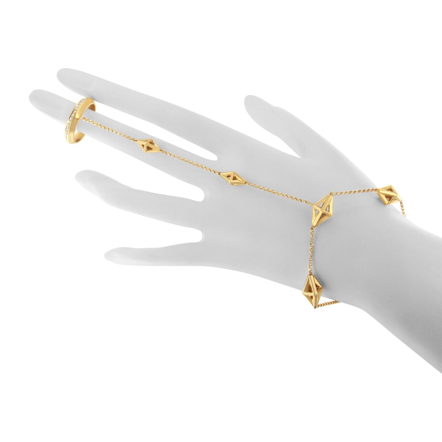 Yellow metal bracelet with geometric shapes and a matching ring with white gemstones in pave setting, displayed on a gray hand model, shown from a top angle.