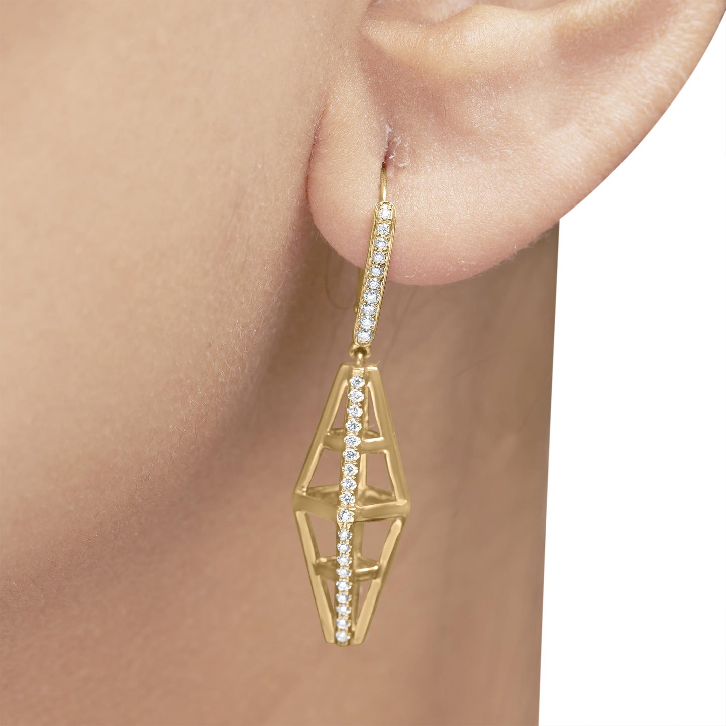 Close-up side view of a yellow metal earring on a model's ear, featuring a geometric cage design with two rows of white round pave-set gemstones.