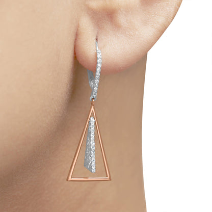 Close-up side view of a two-tone earring on a model's ear with a white metal upper part featuring small white gemstones in pave setting and a rose metal open triangular shape dangling below.