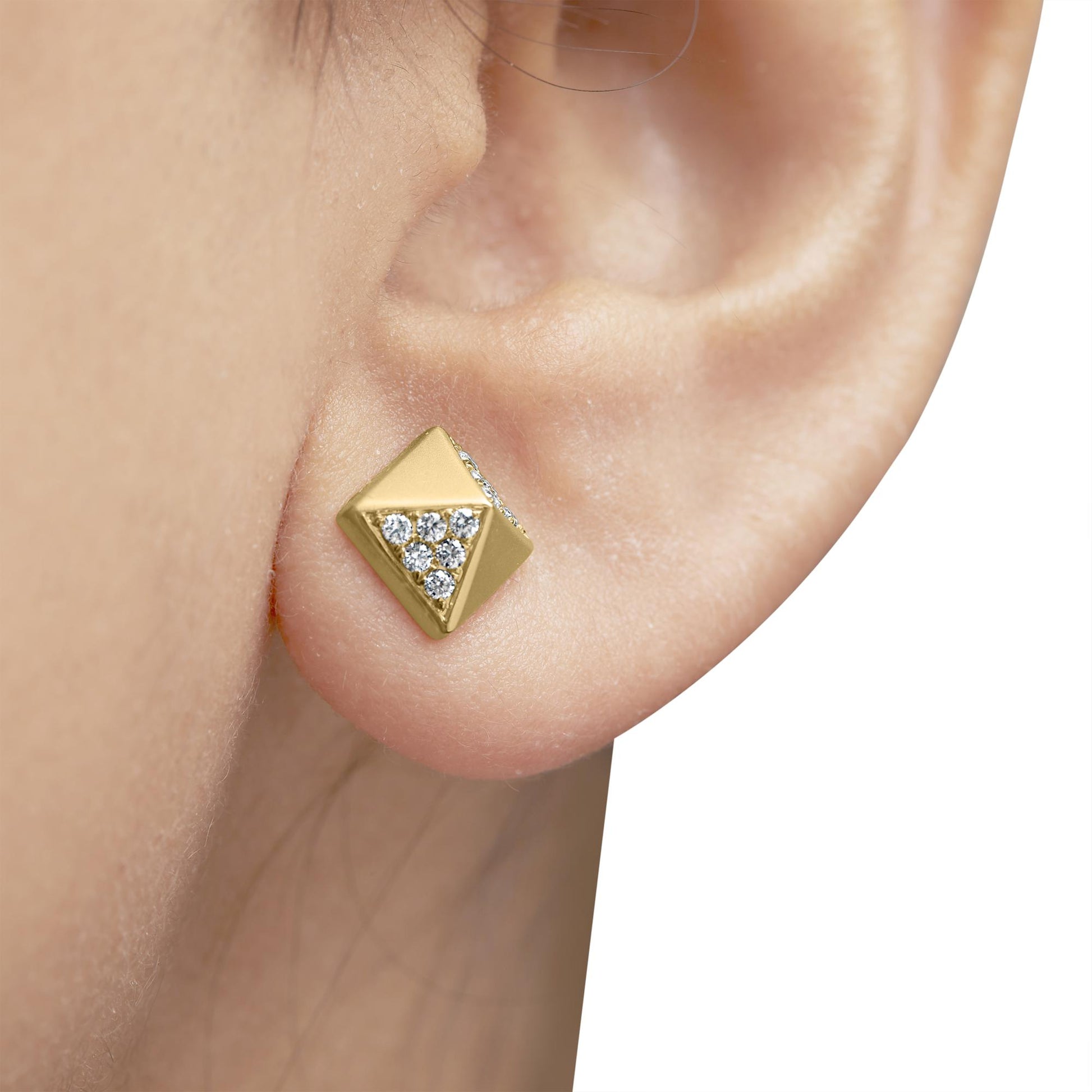 Close-up side view of a yellow metal square-shaped stud earring with round white gemstones set in a triangular pattern, worn on a model's ear.