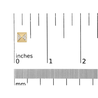 Close-up front view of a yellow metal square stud earring with white round gemstones in prong settings, placed on a ruler for size reference.