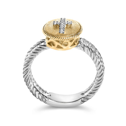 Ring shown from the front angle with a twisted white band and a raised textured yellow round top featuring a cross design set with white round gemstones in a shared prong setting.