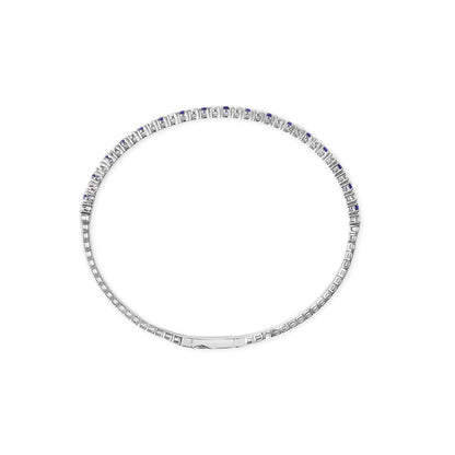 Top view of a white bracelet with alternating round white gemstones and blue gemstones in prong settings, shown on a white background.