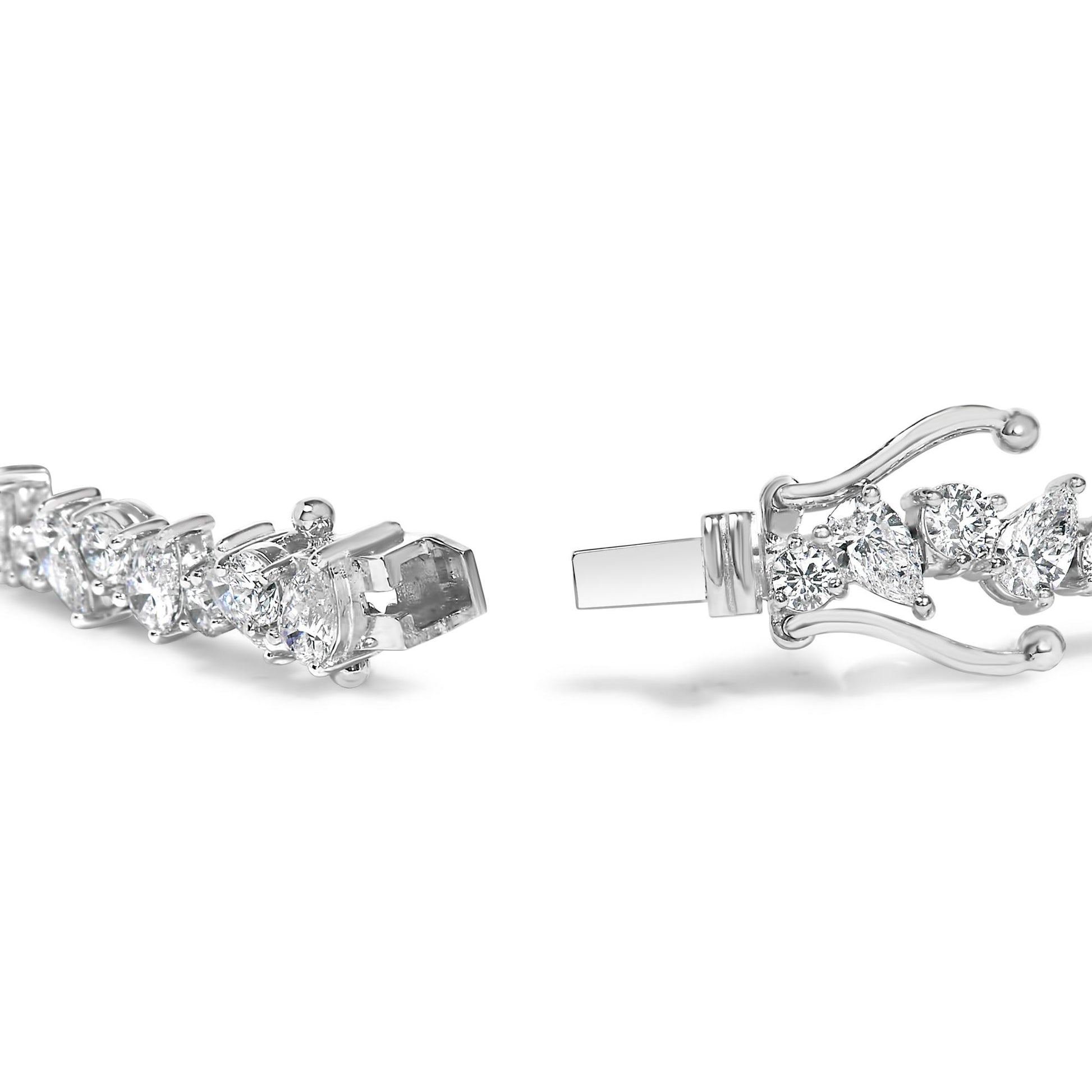 Close-up side angle of a white metal bracelet with alternating pear-shaped and round white gemstones set in three-prong settings, showing the clasp open.