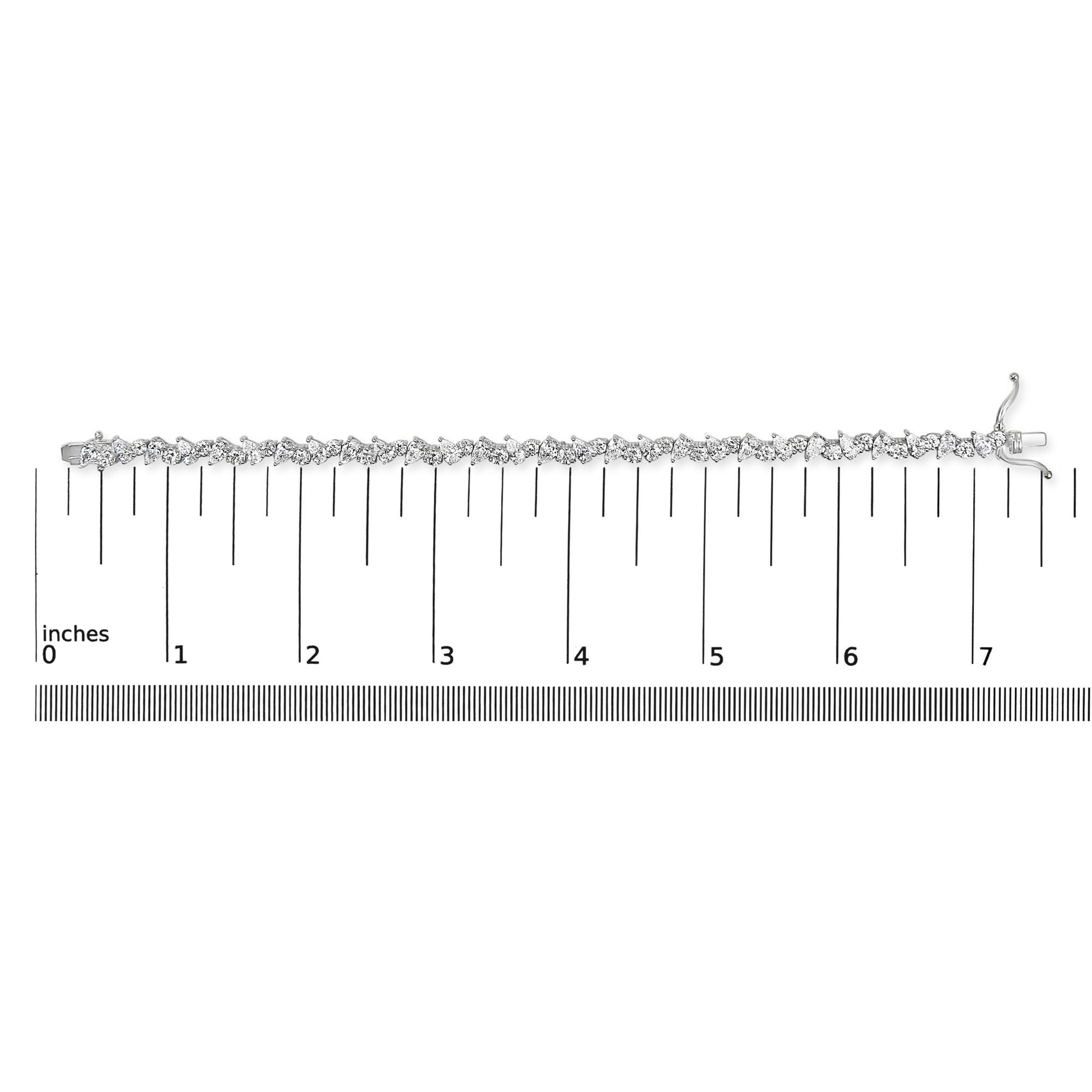 White metal bracelet with alternating pear-shaped and round white gemstones in 3-prong settings, displayed flat on a ruler for size reference, shot from above.
