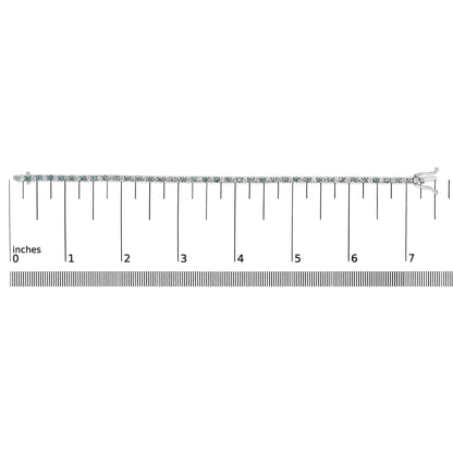 White metal bracelet with alternating white and blue round gemstones in four-prong settings, laid flat on a ruler for size reference, shown from a top-down angle.