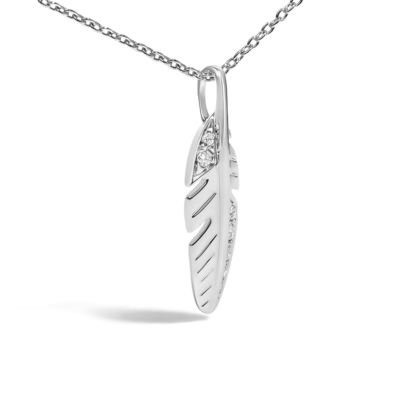 Close-up front angle of a white metal feather-shaped necklace pendant with round white gemstones in pave setting, shown hanging on a chain against a white background.