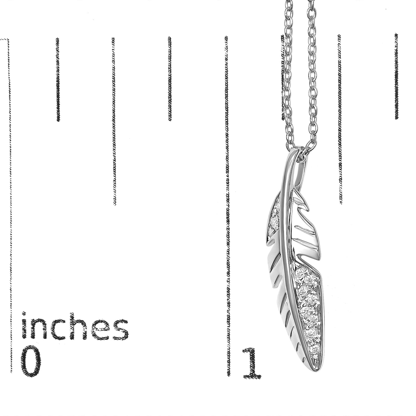 Close-up front view of a white metal feather-shaped necklace pendant with small round white gemstones set in a pave style, shown on a scale.