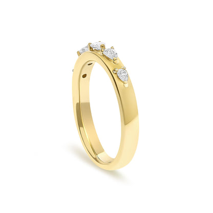 Close-up angled view of a yellow metal ring featuring pear-shaped white gemstones in 3-prong settings evenly spaced around the band.