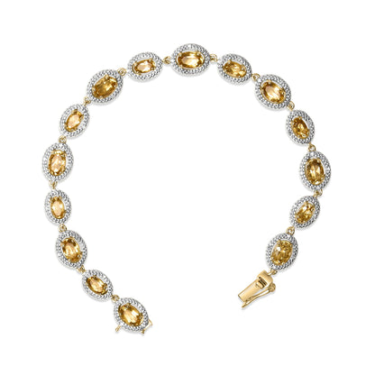 Yellow metal bracelet shown from above, featuring linked oval yellow gemstones surrounded by small white gemstones in a pave setting, with a clasp visible at one end.