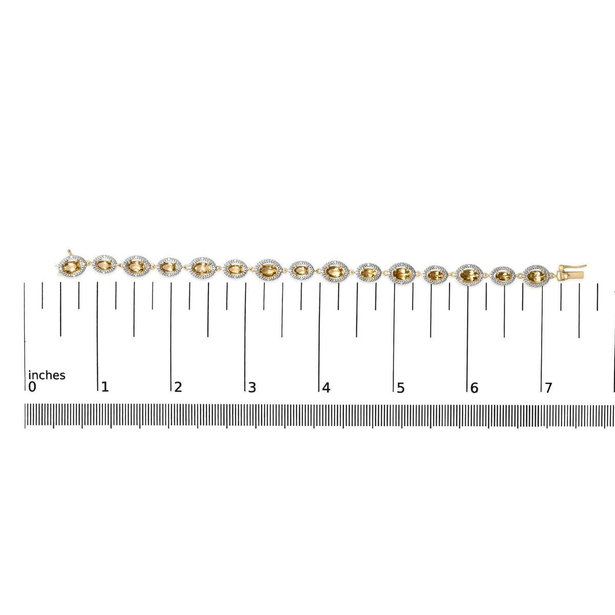 Yellow metal bracelet with alternating oval yellow gemstones surrounded by small white gemstones in a pave setting, shown on a flat surface with a measuring scale, front view.