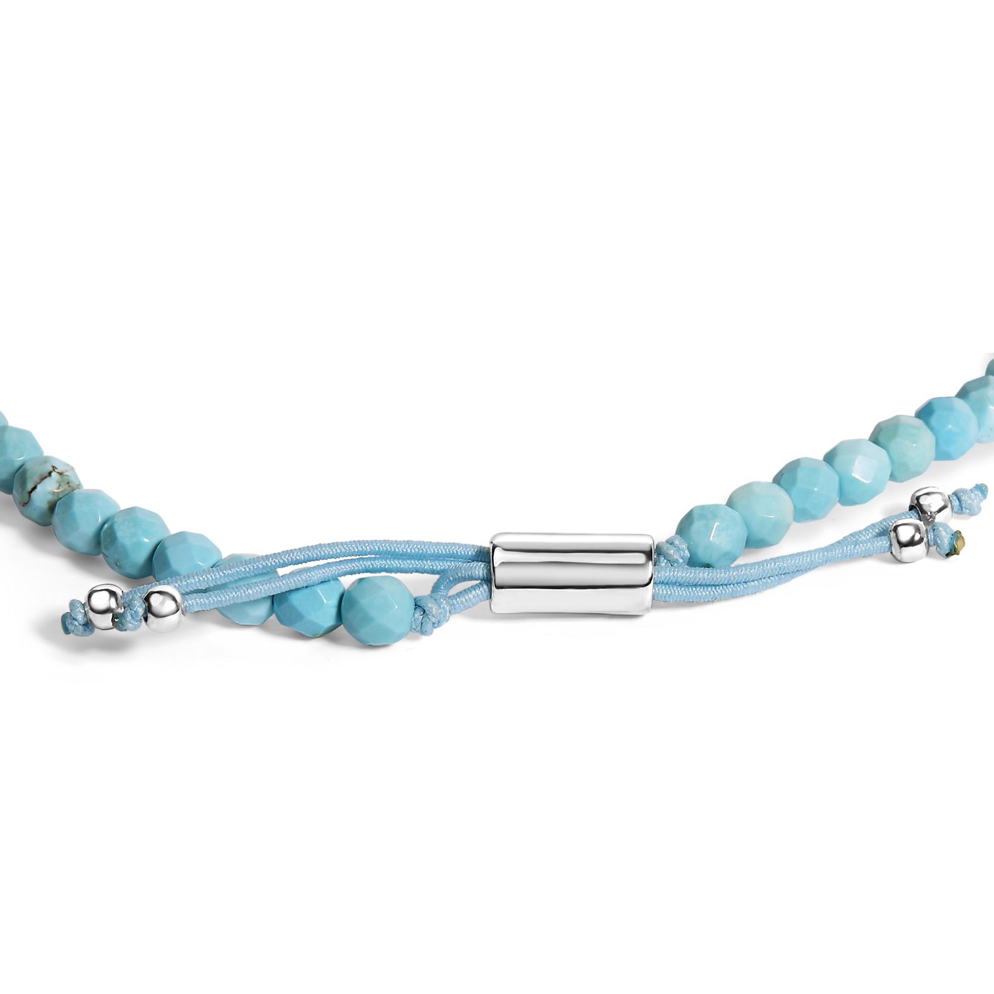 Close-up front angle of a white metal bracelet featuring smooth cylindrical clasp, light blue cord, and faceted blue beads with small white metal beads on the ends.