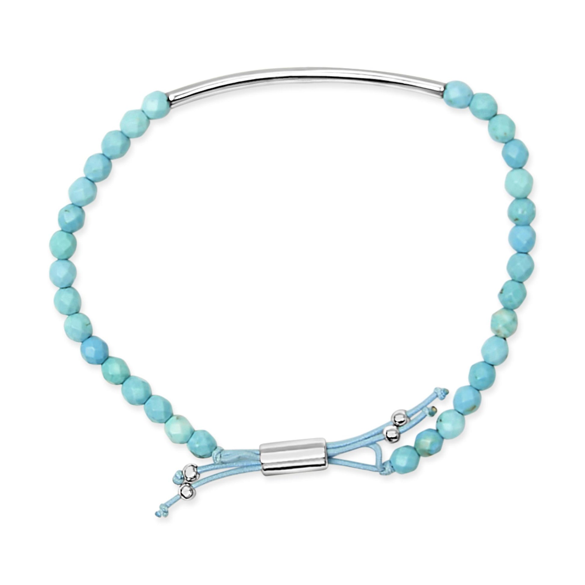White metal bracelet with turquoise beads and an adjustable cord, shown from a top-down angle.